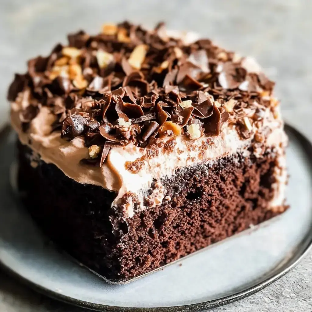 A rich chocolate dessert with whipped cream and candy bits on a gray plate.