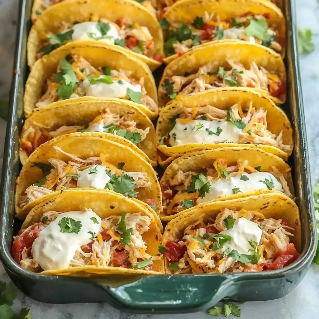 Baked tortillas filled with chicken, cheese, tomatoes, cilantro, and sour cream sit together in a pan ready to serve.