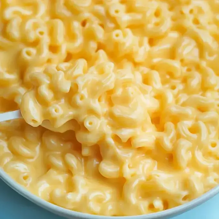 A close look at gooey mac and cheese with a spoon scooping some out.