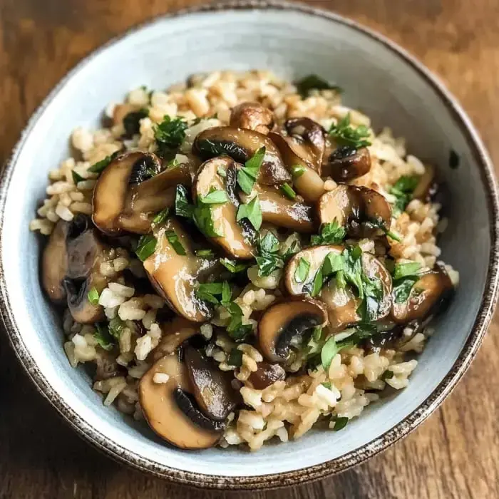 Steamy bowl with brown rice, sautéed mushrooms, and a sprinkle of parsley.