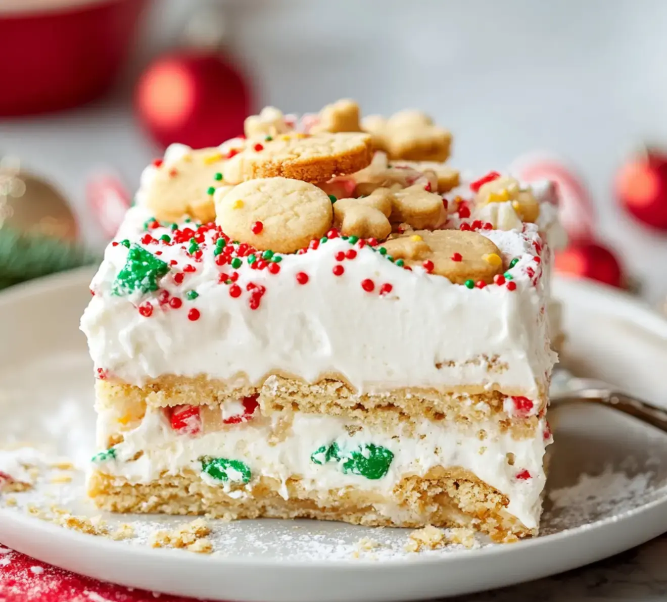 Holiday treat with whipped cream, colorful sprinkles, and festive cookies layered and displayed on a plate.