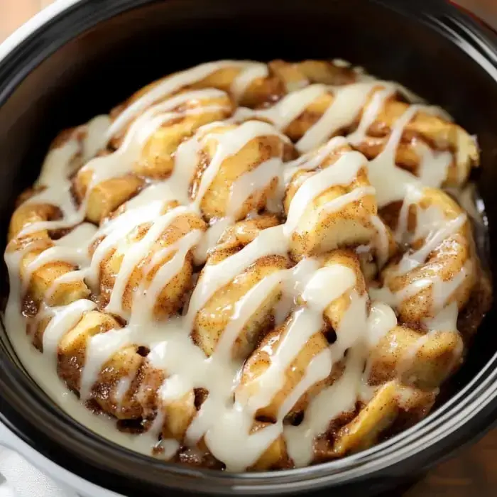 Close look at cinnamon roll chunks topped with creamy white icing.