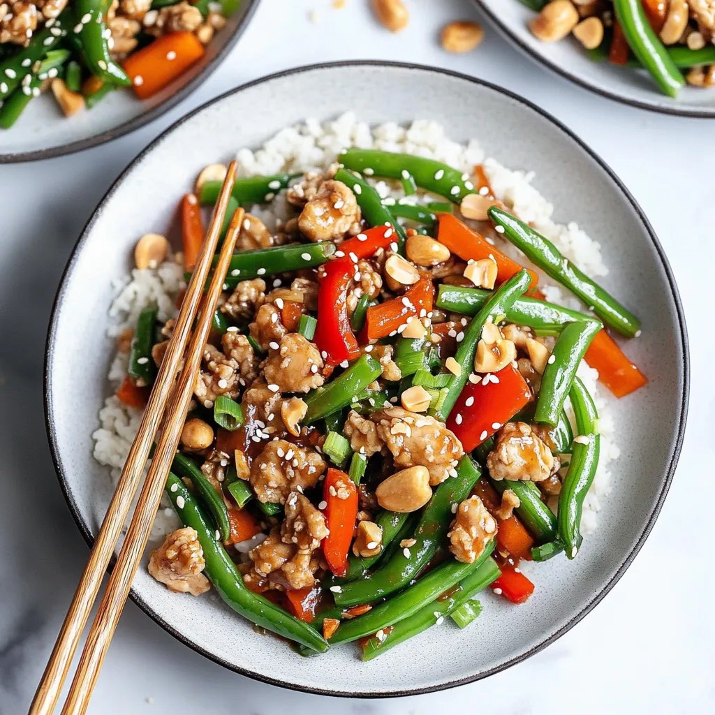 A colorful plate of chicken with veggies like green beans and peppers, served with chopsticks.