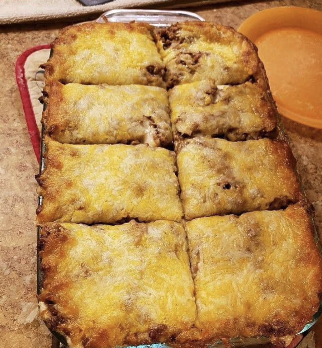 A yellow cheese-topped casserole in a dish.
