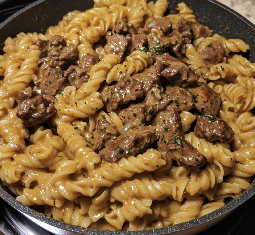 A dish filled with pasta, steak, and cheese.