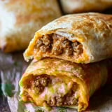Crispy golden tortilla pockets stuffed with seasoned meat and gooey cheese, laid out on parchment paper.