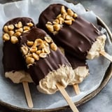 Chocolate-coated yogurt bars on a dish with crushed peanuts sprinkled on top.