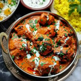 Tender chicken curry topped with fresh cilantro served alongside spicy yellow rice.